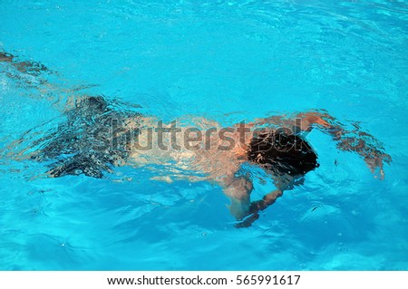 Man swimming underwater in the swimming pool
