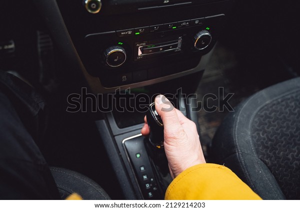 The man switches the gearbox on the automatic. A\
car with an automatic transmission. Speed control system. High\
quality photo