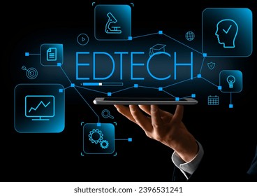 Man with tablet computer and virtual screen with text EDTECH on dark background