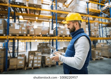 Man With Tablet And Drone Controller In A Warehouse.