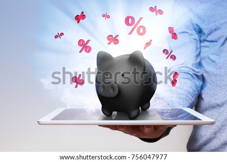 Man with tablet pc and black piggy bank with red percents on the display.