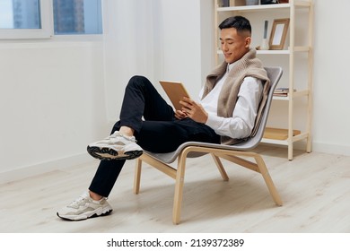 man with a tablet sits in a chair communication Lifestyle - Powered by Shutterstock