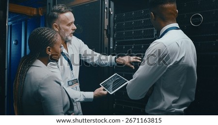 Man, tablet and team with maintenance in server room with cybersecurity, system check or collaboration. Programmer, tech and group with advice for programming, review or IT solution at data center