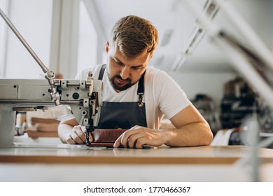 Man tailor working with leather fabric