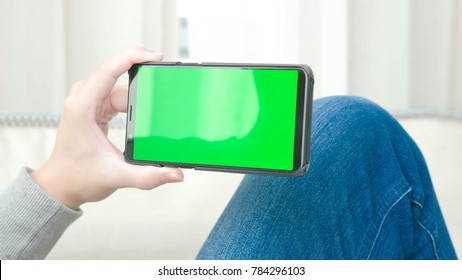 Man Take Cell Phone With Green Screen In The Home