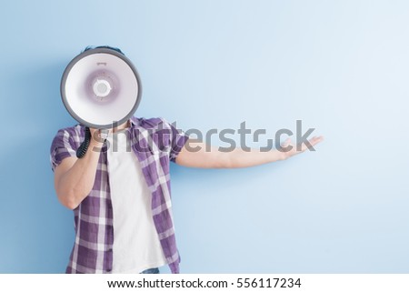man take microphone and show something to you isolated on blue background