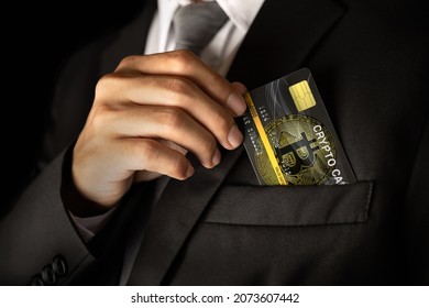 Man take out the Crypto card from the suit pocket. - Shutterstock ID 2073607442
