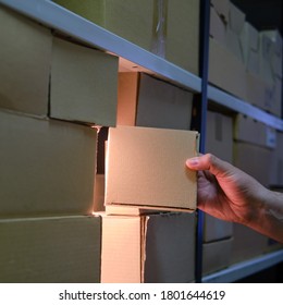 Man Takes A Box From A Warehouse At Night