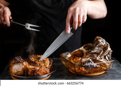 Man takes cooked pieces of marinated pork shoulder from roasting sleeve - Shutterstock ID 663256774