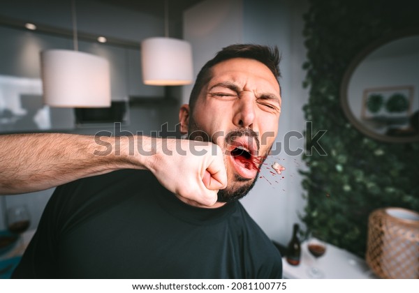 Man takes hard punch in the face. Two man\
fighting. Man hitting beaten man in the face with fist. Conflict\
and violence concept