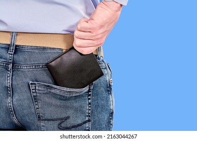 The man takes out a black purse from his back pocket, close up