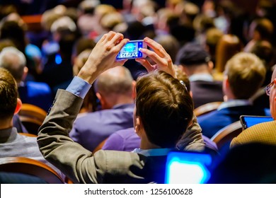 Man Takes A Picture Of The Presentation At The Conference Hall Using Smartphone