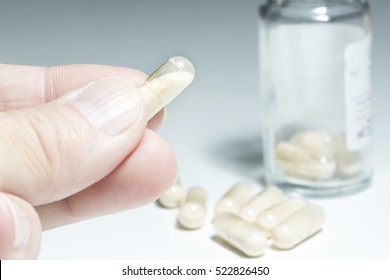 Man Takes  Probiotic Transparent  Capsule, White Background