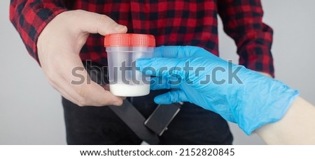 Man takes semen analysis. Spermogram. Concept. Male with his pants unbuttoned symbolizes preparation for analysis of seed for infertility, sperm motility. Suitability test for artificial insemination
