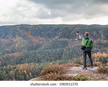 Man takes smart phone mobile photo on mountain landscape. Autumn season hike - Powered by Shutterstock