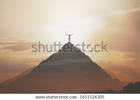 man taking a breath in peak of the montain