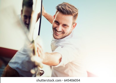 Man Taking Care And Cleaning His Car Outdoors.