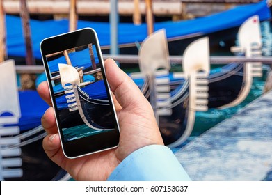 Man taking a closeup picture of a gondola with his Smartphone in hand