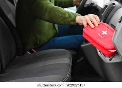 Man taking first aid kit from car's glove compartment