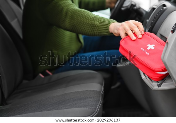 Man\
taking first aid kit from car\'s glove\
compartment