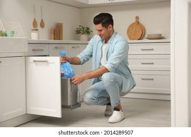 Man Taking Garbage Bag Out Of Bin At Home