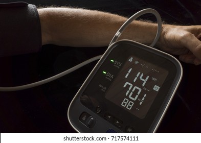 Man Taking His Own Blood Pressure With A Digital Home Blood Pressure Monitor