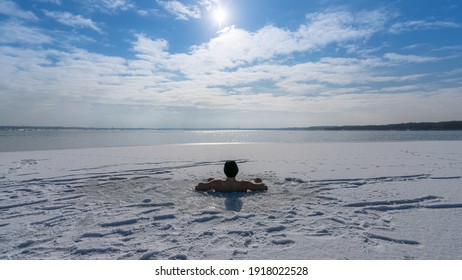 Man taking an ice bath in an ice hole