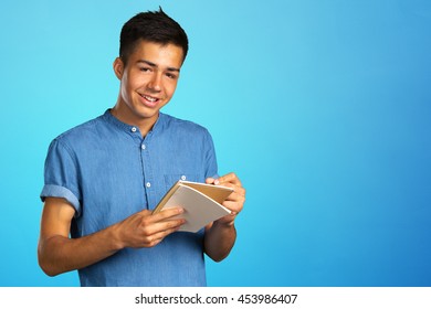 man taking notes on his notebook