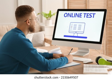 Man Taking Online Test On Computer At Desk Indoors