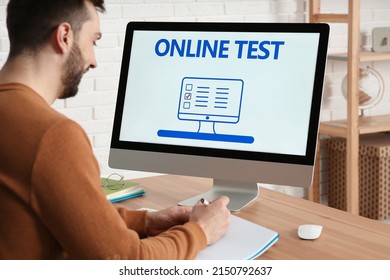 Man Taking Online Test On Computer At Desk Indoors