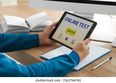 Man Taking Online Test On Tablet At Desk Indoors, Closeup