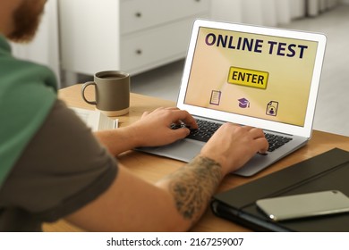 Man Taking Online Test On Laptop At Desk Indoors, Closeup