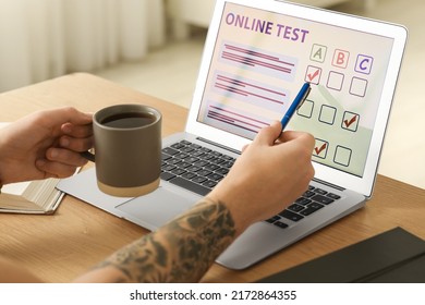 Man Taking Online Test On Laptop At Desk Indoors, Closeup