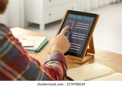 Man Taking Online Test On Tablet At Desk Indoors, Closeup