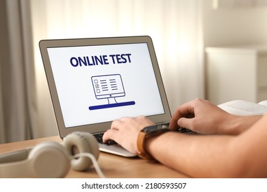 Man Taking Online Test On Laptop At Desk Indoors, Closeup