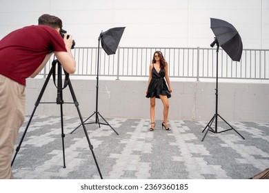 Man taking photo of beautiful fashion girl outdoors, fashion shoot concept - Powered by Shutterstock