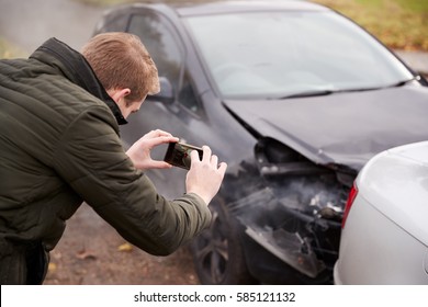 Man Taking Photo Of Car Accident On Mobile Phone