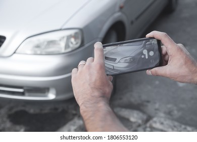 Man Taking Photo Of A Car On His Phone.