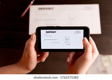 Man Taking Photo Of Cheque To Make Remote Deposit In Bank.