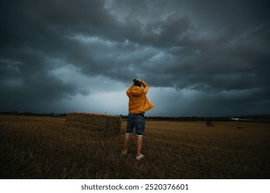 Man taking photos of a storm cloud over field, tornadic supercell. - Powered by Shutterstock