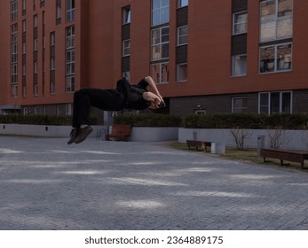 Man taking photos while doing somersault outdoors. 