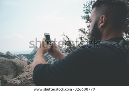 Man taking picture with phone camera of landscape