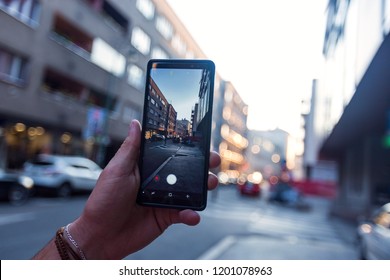 Man Taking A Picture In The Street With His Smartphone