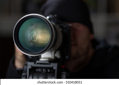 Man taking pictures of cheaters with a large telephoto lens - Powered by Shutterstock