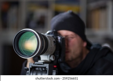 Man Taking Pictures With Large Telephoto Lens