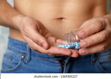 Man Taking Pills, Bottle With Blue Tablets In Male Hands Close Up. Muscular Guy In Unzipped Jeans With Naked Torso, Concept Of Viagra, Medication For Stomach, Erection, Sleeping Or Digestive Pill