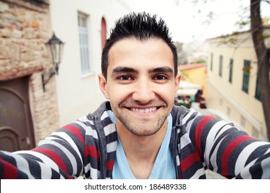 Man Taking Self Portrait In The Europe Streets.Athens,Greece.Smiling Young Man.Travel Selfie.