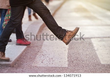 Man taking the step (onto zebra crossing)