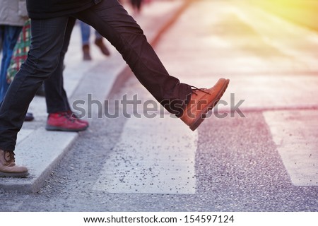 Man taking the step (onto zebra crossing)