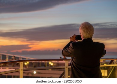 Man Taking A Sunset Picture On A Cruise